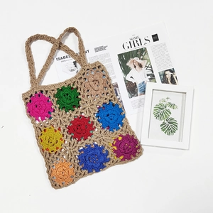 Close-up of colorful handmade crochet tote bag featuring multi-color floral patterns