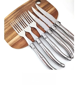 Laguiole style stainless steel cutlery set with ABS handles on a wooden board
