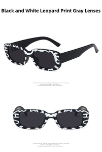 Detail view of small square sunglasses with black and white leopard pattern and grey lenses