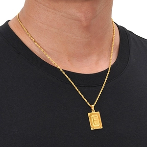 Close-up of golden rectangle pendant with letter E on a minimalist twisted chain necklace