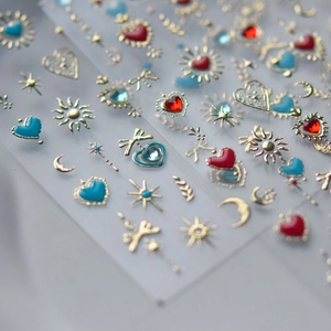 Exquisite nail art stickers featuring golden heart, sun, and moon motifs with colorful gems