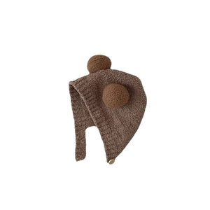 Plush baby earflap hat in dark brown with twin pom-poms and secure button strap