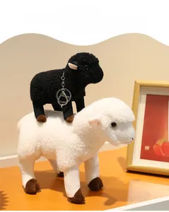 Détail de poupées moutons en peluche noir et blanc en laine bouclée avec sabots bruns