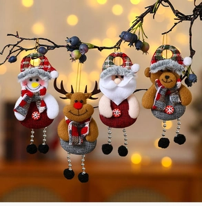 Detail of Christmas plush ornaments including Santa and Reindeer hanging on a tree branch