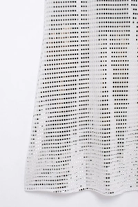 Vista macro di paillettes quadrate argento su tessuto a rete bianco per abiti da sera