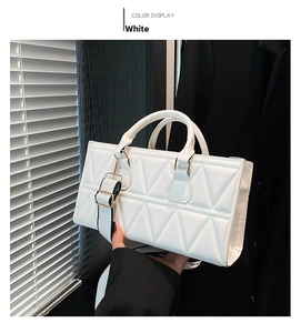 Detail view of white rhombic quilted leather handbag with gold-tone hardware and wide strap