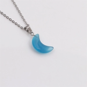 Détail d'un collier avec pendentif croissant de lune bleu poli et chaîne en métal argenté