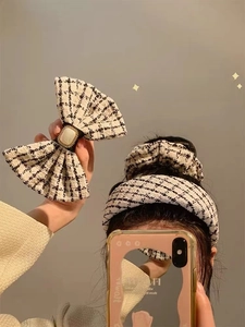 Close-up of black and white tweed hair accessories with elegant pearl jewel details