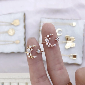 Detailed close-up of gold-plated moon and star rings with zircon and pearl accents