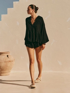 Detail of black cotton linen two-piece set featuring puff sleeves and textured fabric