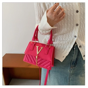 Detailed close-up of rose red leather square bag with diamond quilted pattern and V-clasp