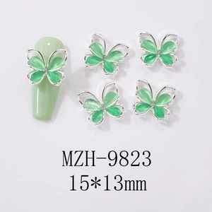Macro detail of mint opal butterfly nail charms with silver frame and mini rhinestones