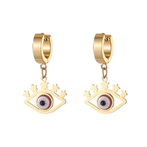 Close-up of golden evil eye hoop earrings with hollow eyelashes and small star charms