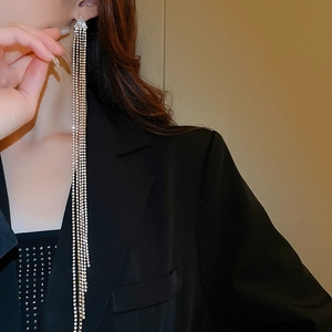 Dettaglio di lunghi orecchini a cascata in argento con strass su una modella