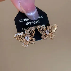 Gold plated silver butterfly stud earrings with sparkling cubic zirconia on a black card