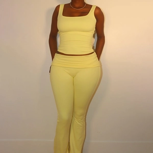 Detail view of yellow square neck slim fit tank top and high waist flared trousers set