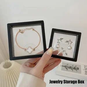Black PE film floating jewelry display box holding clover bracelet and earrings