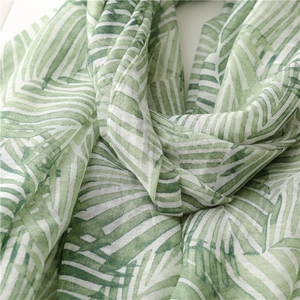 Detailed texture of green leaf pattern on soft cotton linen travel sunscreen scarf