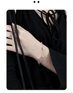 Detail showing an elegant S925 silver bracelet with oval charms and a hollow grid ring
