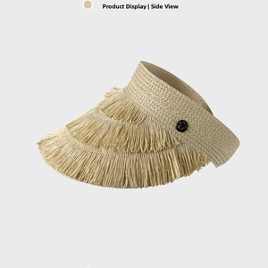 Detailed side view of beige straw visor with fringed edges and metal logo buckle