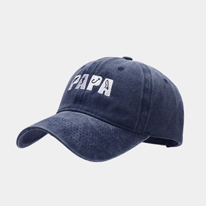 Macro shot of the PAPA embroidery with fishing motifs on a navy washed cotton baseball cap