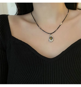 Detail view of a vintage double-layer necklace with tiger eye stone and black cord