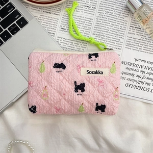 Detail of floral quilted pouch with cat and pear patterns and green zipper pull