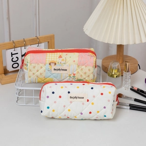 Detailed close-up of quilted cotton pencil cases with colorful patterns and red zippers