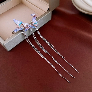 Clip d'oreille papillon dégradé violet avec pampilles en argent sur fond en velours