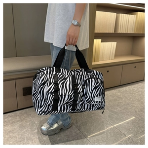 Close-up of zebra print travel bag showing black and white canvas texture and durable straps