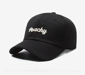 Detailed close-up of white Peachy 3D embroidery on a black cotton twill baseball cap
