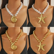 Macro shot of chunky gold and pearl necklaces with shell and starfish pendants on models