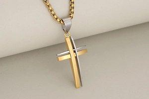 Detail of hollow double-layer stainless steel cross pendant with gold and silver finish