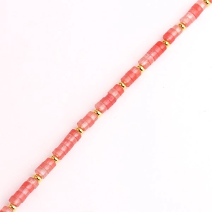 Detalle de piedras cuadradas rosas y cuentas doradas en un collar de titanio dorado
