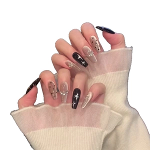 Long coffin press-on nails with black star patterns and cat-eye pearl accents