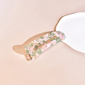Macro detail of acetate hair clip with floral marble pattern and metal snap fastener