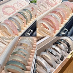Gros plan de bracelets en pierre naturelle comme le quartz rose et l'agate dans un coffret