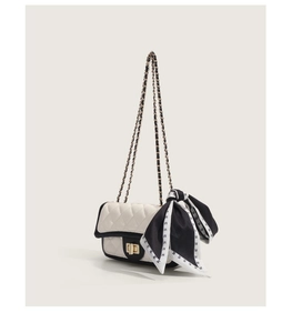 Détail du sac matelassé blanc avec chaîne dorée et ruban noir à motif M élégant