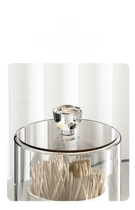 Detail of transparent storage jar with crystal-cut lid handle showing wooden toothpicks