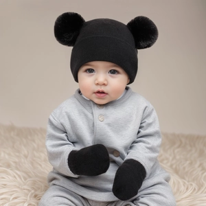 Detail of infant winter set featuring knit pom-pom hat and matching warm mittens