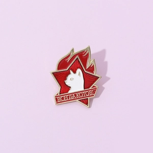 Macro view of a creative enamel brooch featuring a red star and a white cat head design