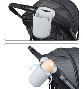 Detail view of a white silicone stroller cup holder showing empty and used bottle storage