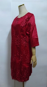 Close-up of red satin dress featuring intricate floral embroidery and vintage lace details