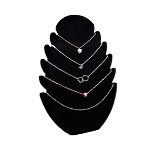 Black velvet L-shaped necklace stand displaying silver and rose gold pendant necklaces