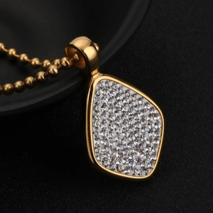 Pendentif goutte en or avec cristaux scintillants sur un fond noir élégant