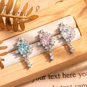 Three round zircon cartilage piercings in blue, pink and white on a wooden display box
