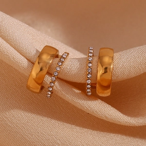 Vue macro de boucles d'oreilles double C plaquées or 18 carats sur de la soie rose