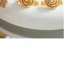 Dettaglio macro di orecchini a rosa in oro 18K con piccoli zirconi trasparenti