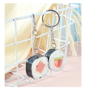 Dettaglio macro di portachiavi a forma di mini sushi appesi a una griglia bianca