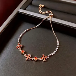 Elegant 18K gold plated flower bracelet with amber crystals on a gray jewelry box